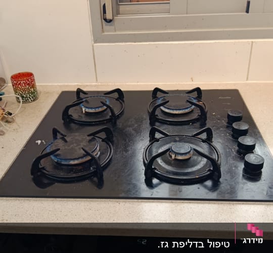 כיריים גז על משטח מטבח עם כלים